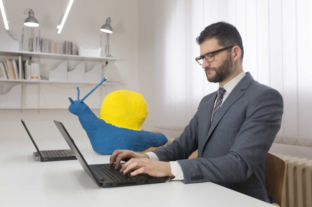Laptop user in a workspace symbolizing slow internet performance